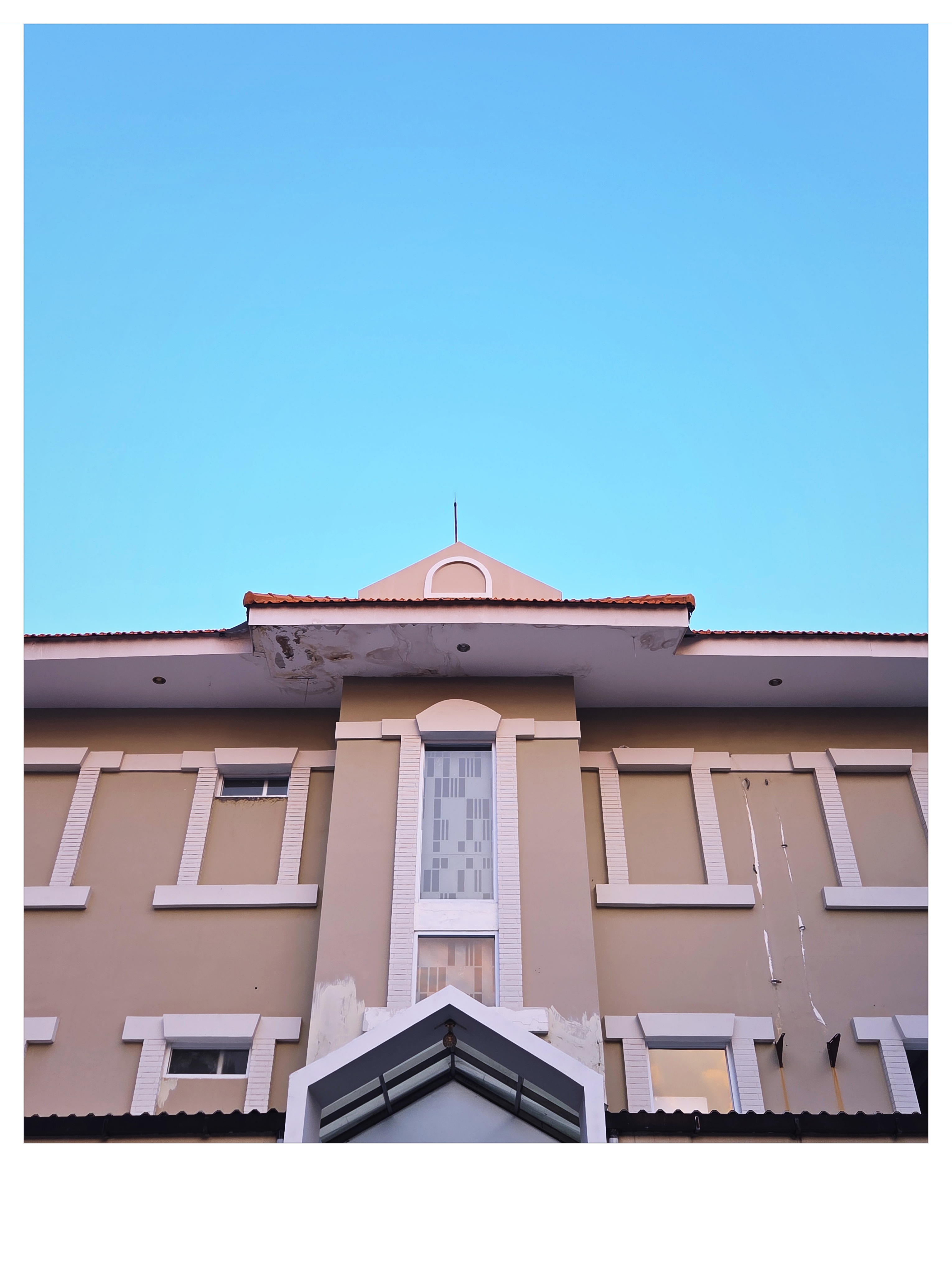 Contemporary architectural facade rising into deep cyan sky shot on NeoFilm Vista Color 200